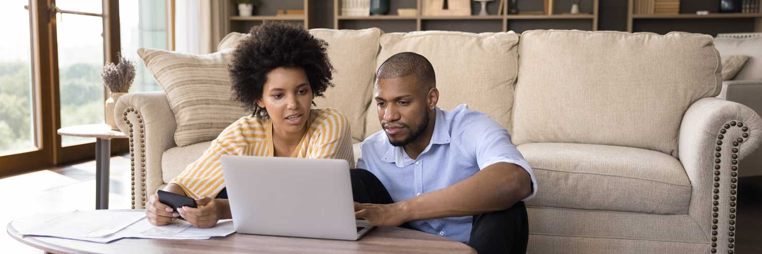 Couple reviews on a computer their options for financing infertility treatments | Ember Fertility Center | Orange County, CA & Irvine