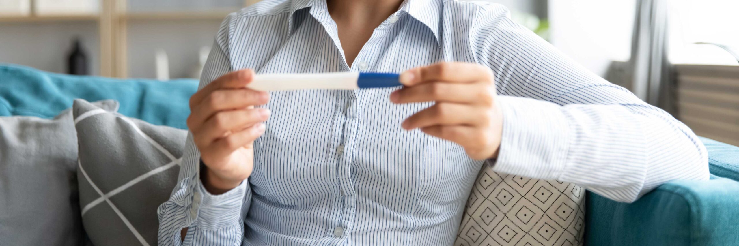 Woman looks at pregnancy test after an IUI treatment at Ember Fertility Center | Laguna Hills & Orange County, CA