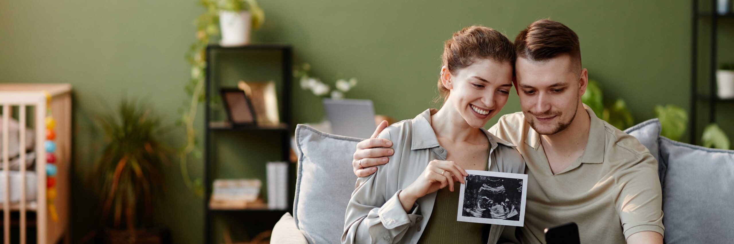 A happy couple with a sonogram image of their baby in the womb | eSET webpage | Ember Fertility | Orange County, CA