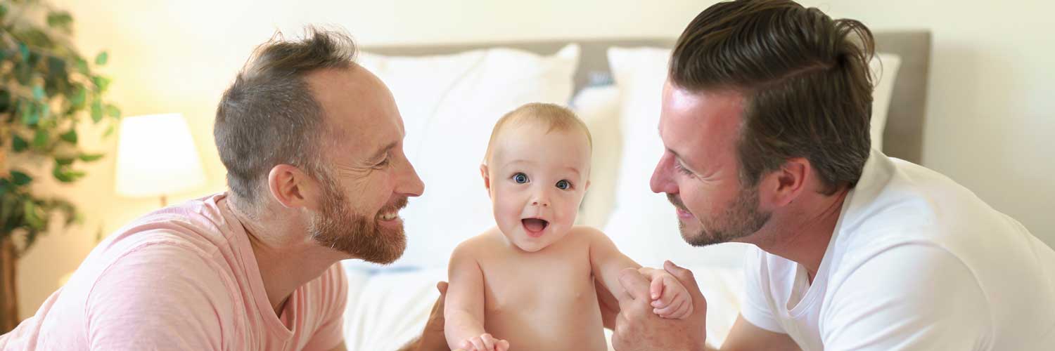 Male couple smiling at their fertility baby | Ember Fertility Center, Orange County